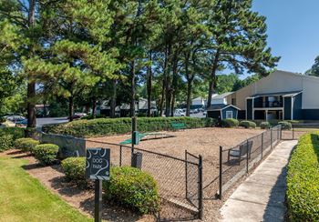 A dog park sign is displayed in front of a fenced area.